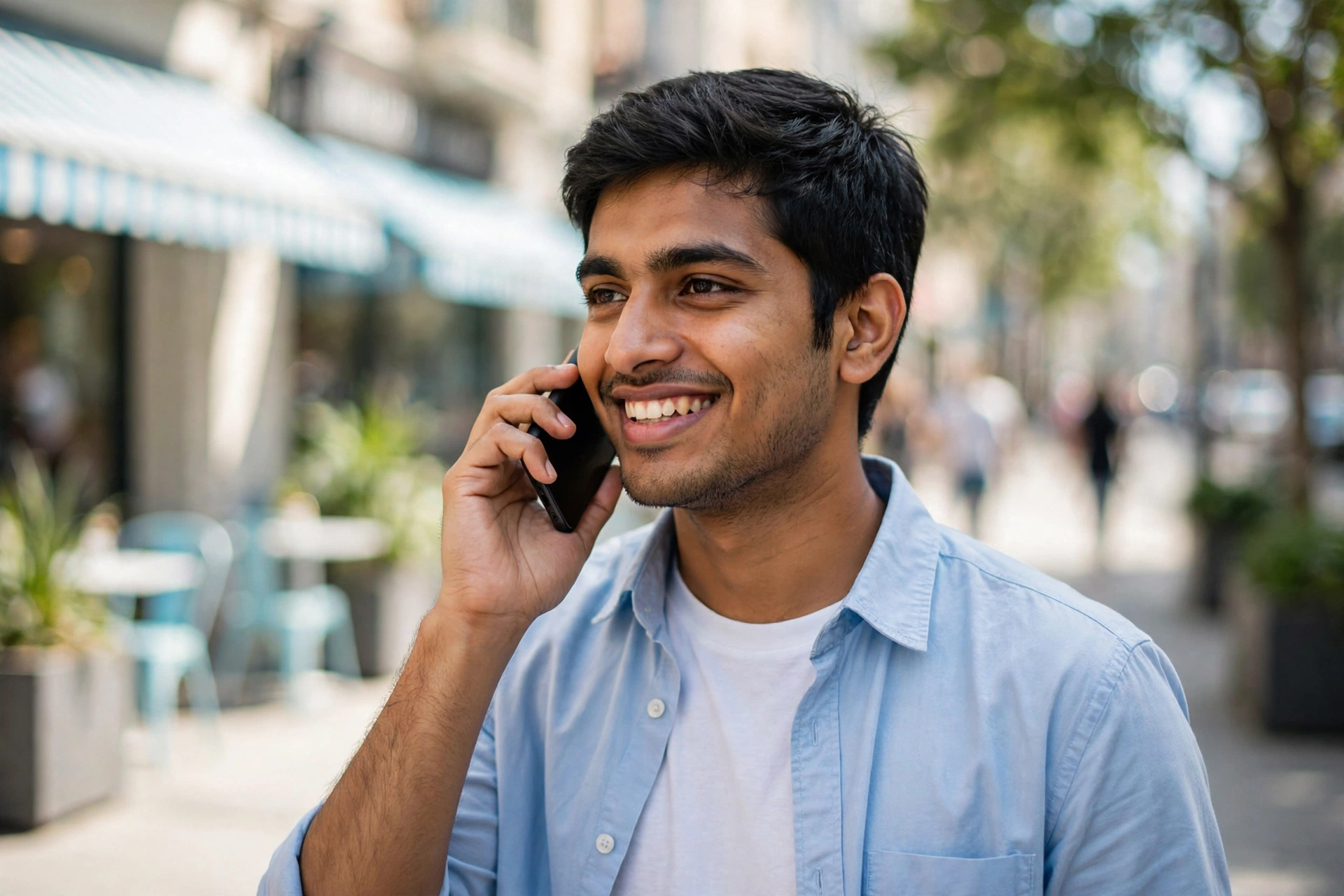 Young man answering a phone survey on a sunny sidewalk